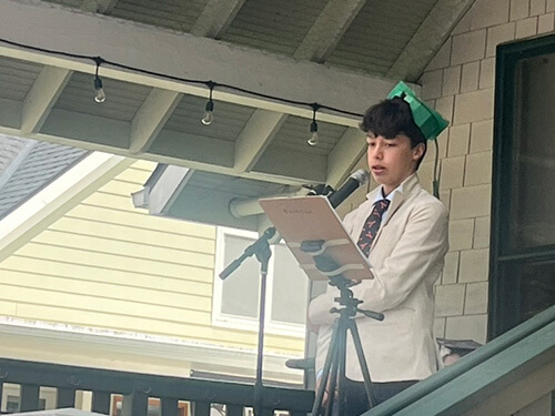admissions-graduates-2 Student speaking into a microphone during a graduation ceremony.